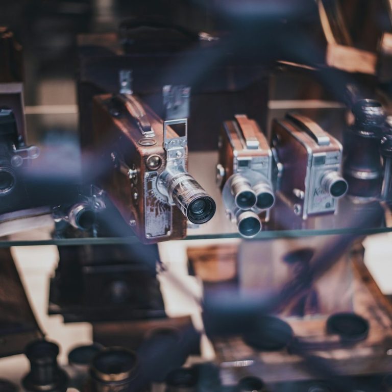 Collection of vintage cameras displayed behind a glass case.